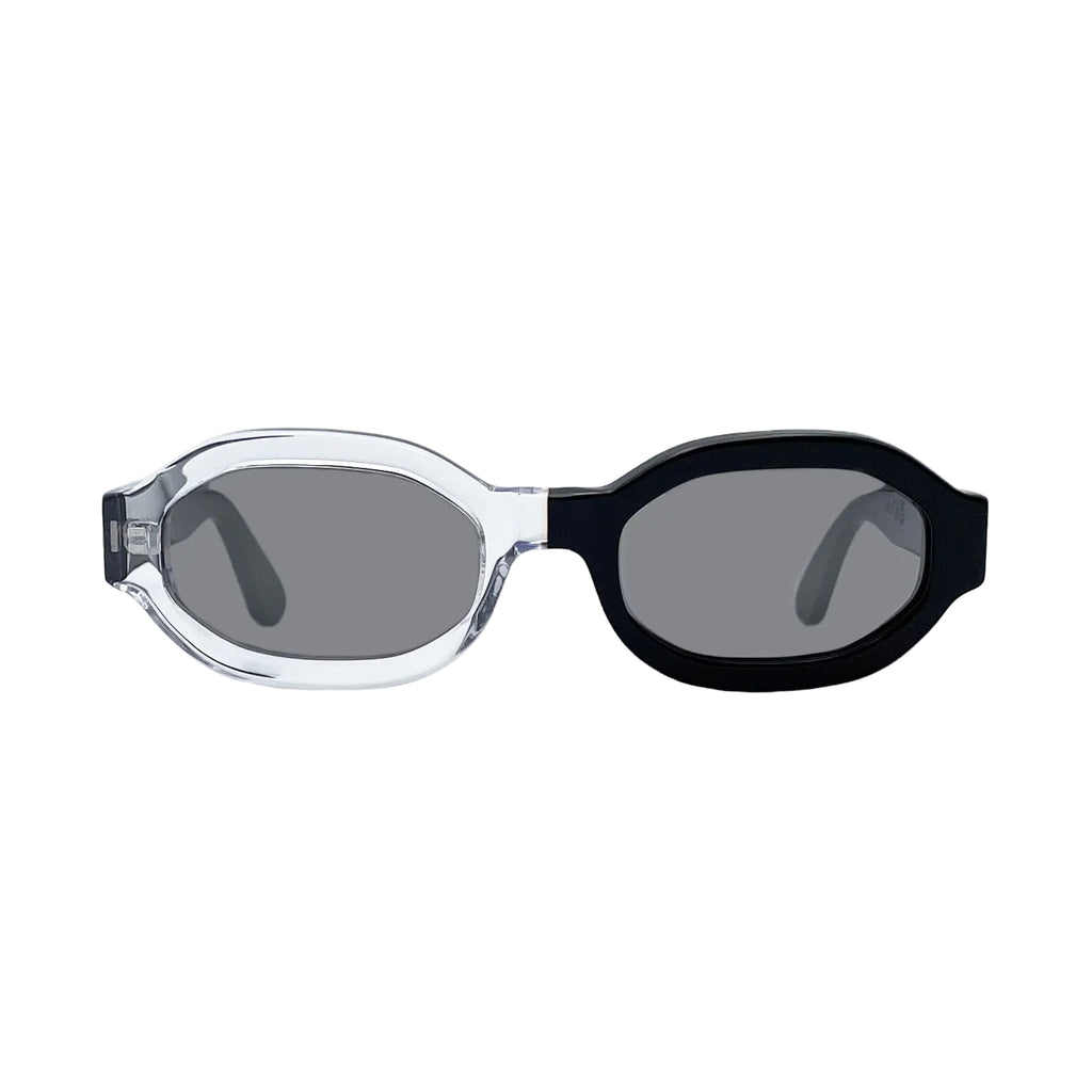 Oversized octagonal sunglasses with a clear transparent frame on the left and a  black frame on the right, featuring dark gray mirror lenses, shown against a plain white background.
