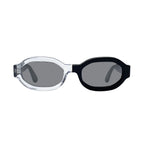 Oversized octagonal sunglasses with a clear transparent frame on the left and a  black frame on the right, featuring dark gray mirror lenses, shown against a plain white background.