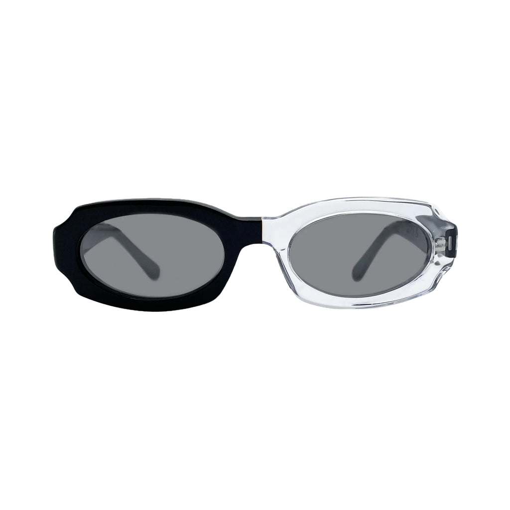 Oversized oval sunglasses with a black acetate front and temple arm, and a clear transparent acetate front, set against a light gray background.