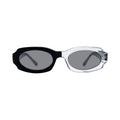Oversized oval sunglasses with a black acetate front and temple arm, and a clear transparent acetate front, set against a light gray background.